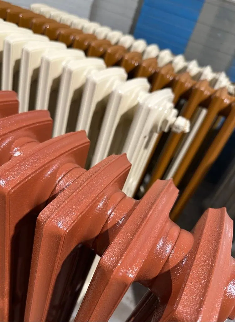 Radiateurs en fonte rénovés et peints — terracotta, crème et orange — dans l'atelier AS DÉCAPAGE